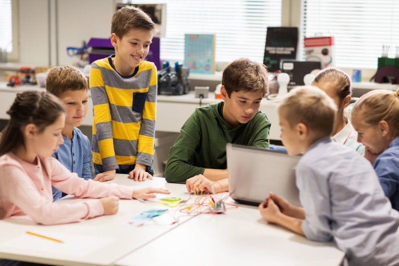 happy children with laptop at robotics school